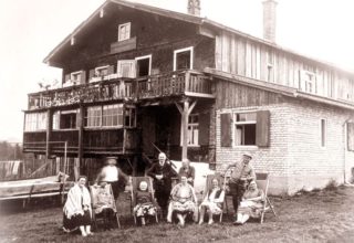 Family posing for photo outside hotel in 1928