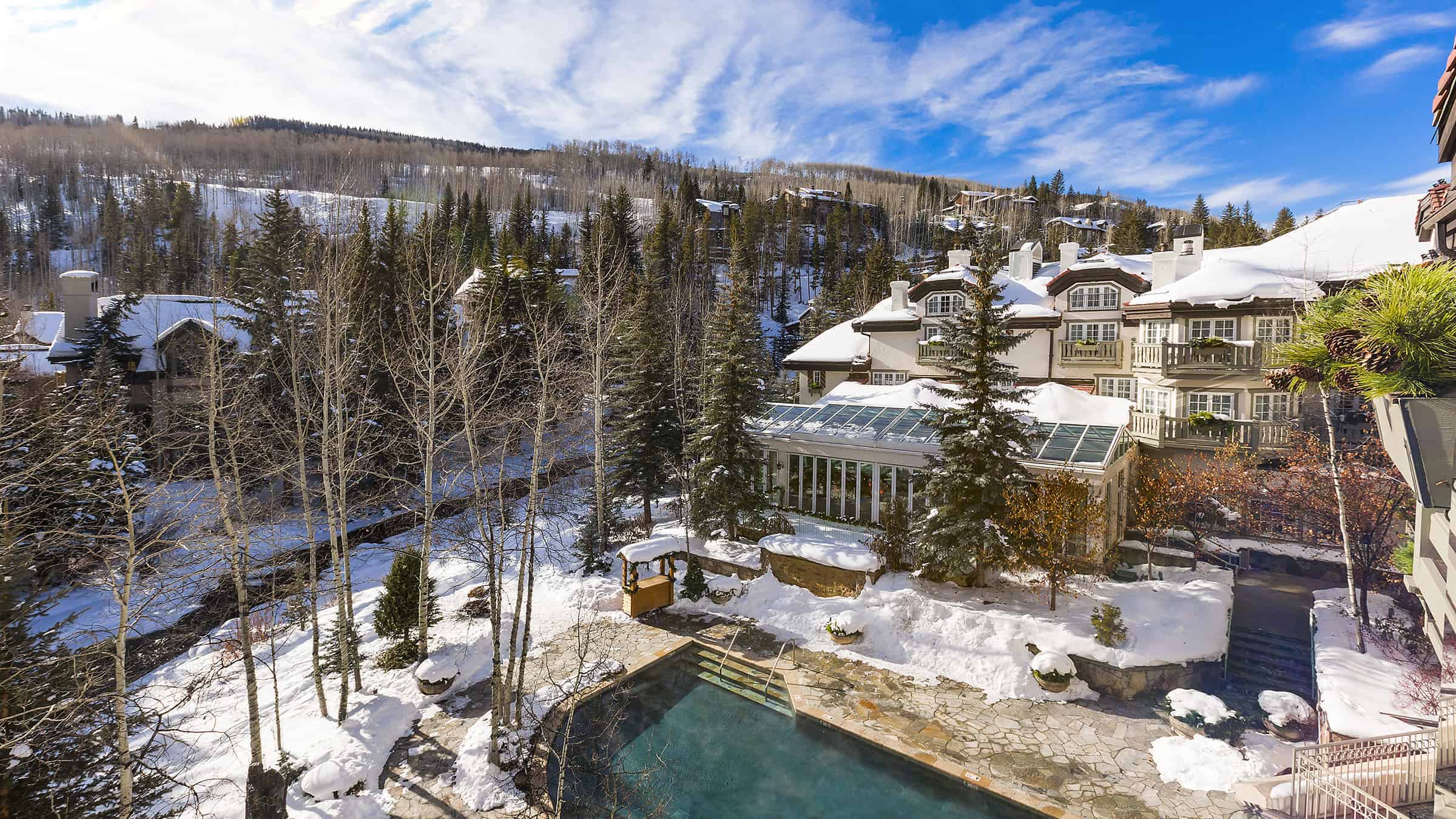 A snowy resort with a pool and mountain view.