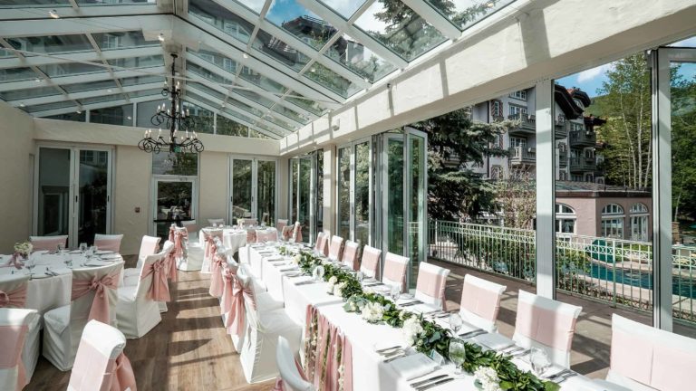 Outdoor terrace with long table and tables with placesettings