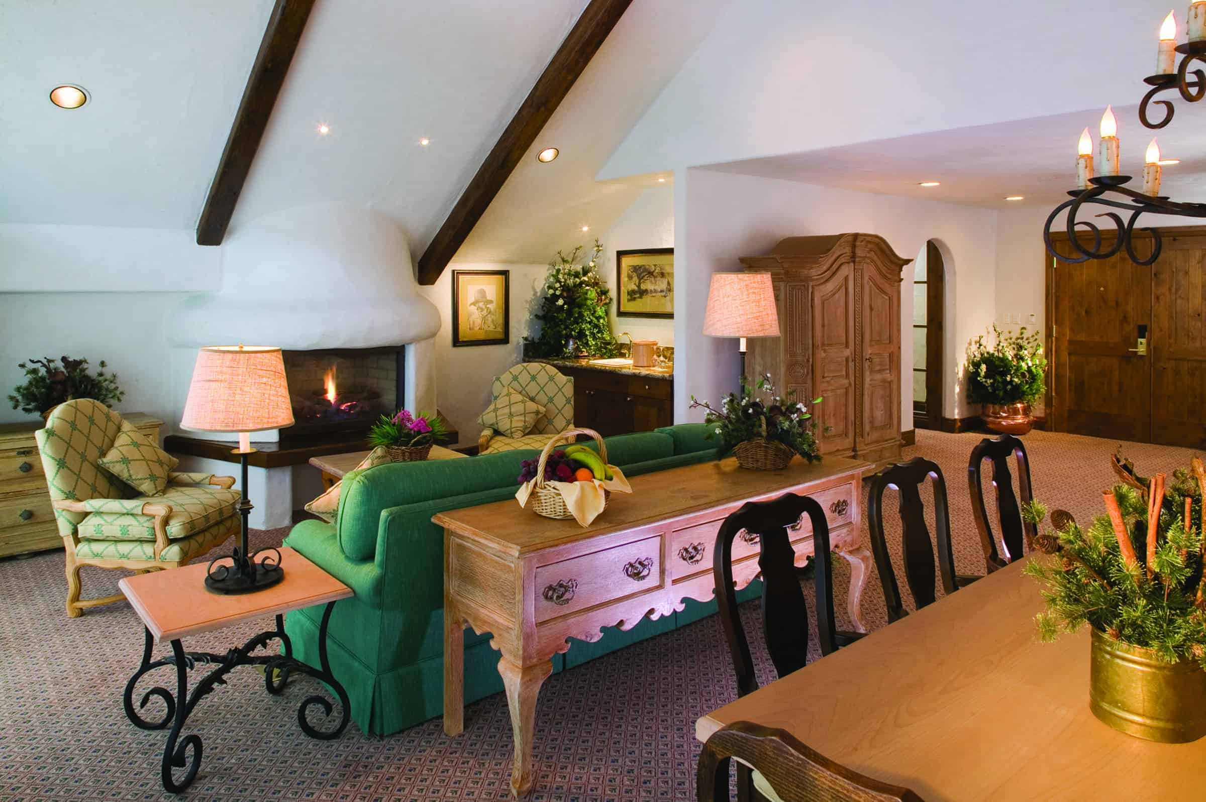 Castle Peak Suite with fireplace, sofa, chairs, and dining table with chairs in foreground
