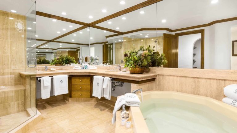 large bathroom with soaking tub, double sink, and showe with glass doors