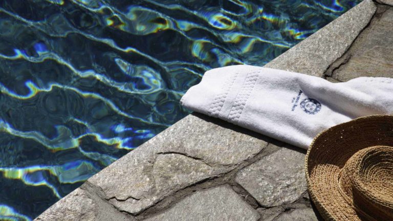 Closeup of towel and hat next to edge of pool