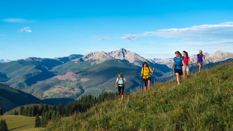 women hiking on a hill in vail colorado