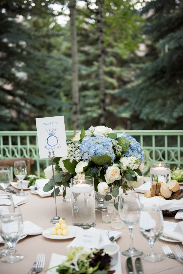 Closeup of outdoor table with centerpiece, various dishes, and place card