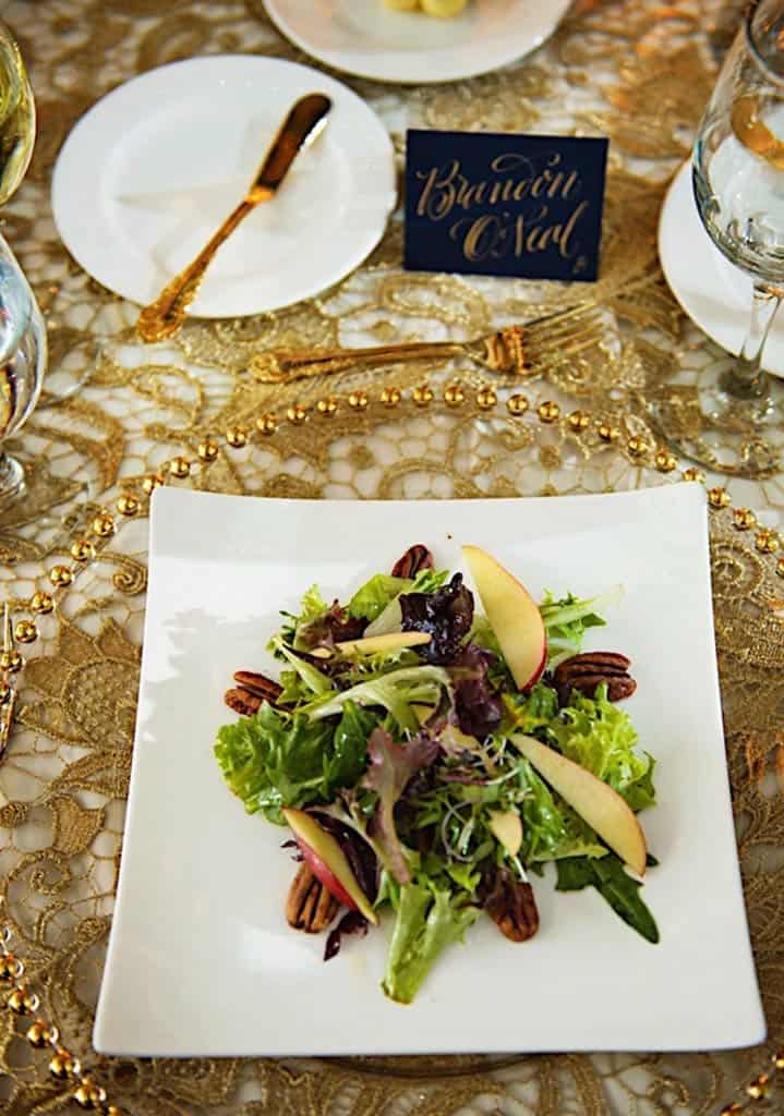 Closeup of square plate wth salad, and place card on tablke