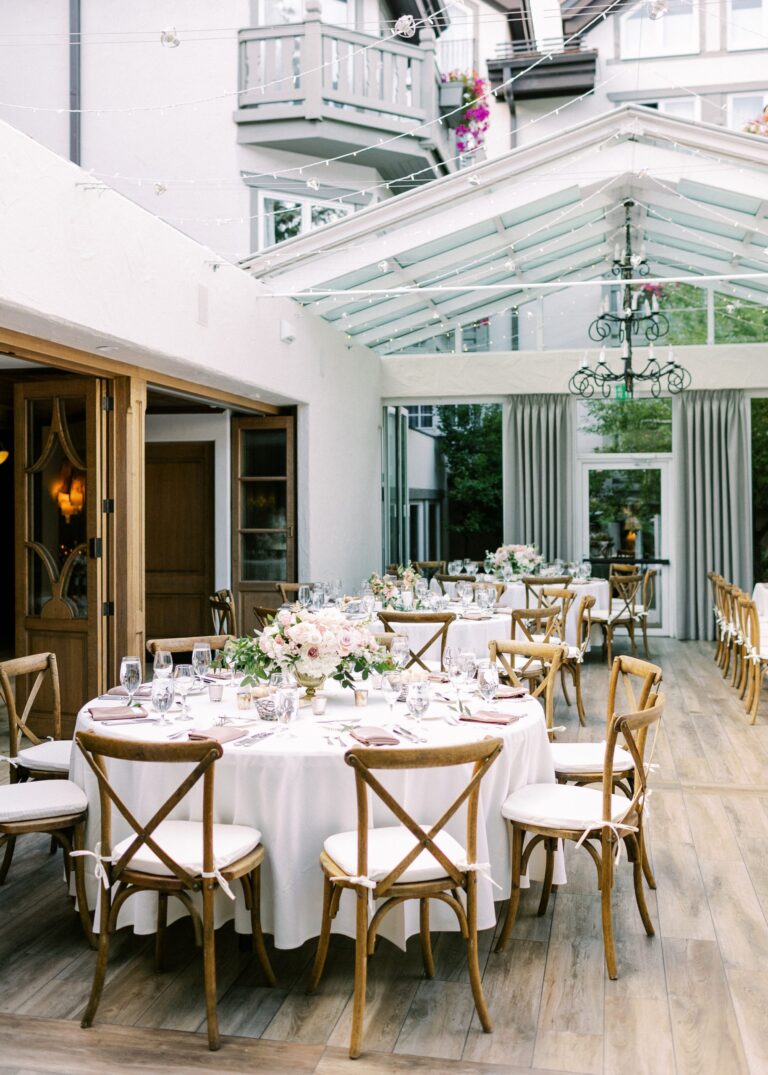 Wedding reception space with tables with placesettings and centerpieces
