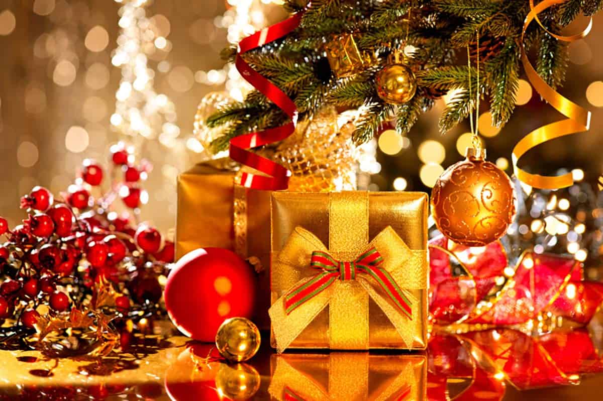 Gifts with golden wrapping paper and bows under Christmas tree