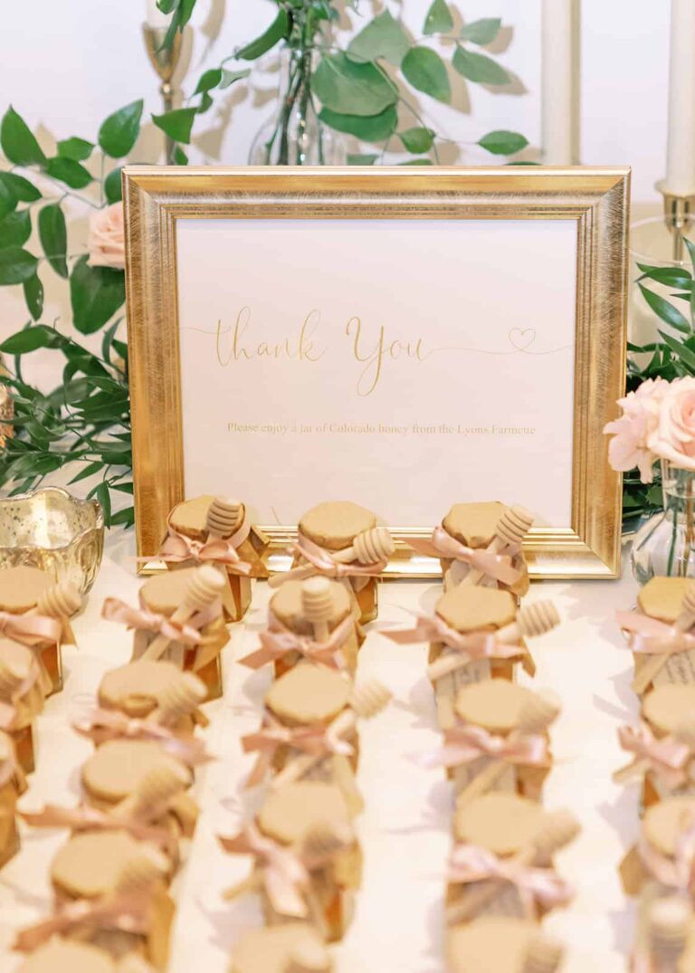 Frame with thank you sign and wedding favor honey jars in the foreground