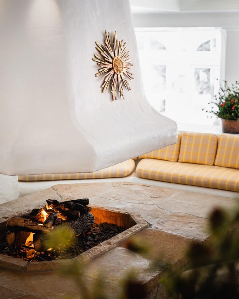 Spa room with stone firepit and cushioned seating area around it