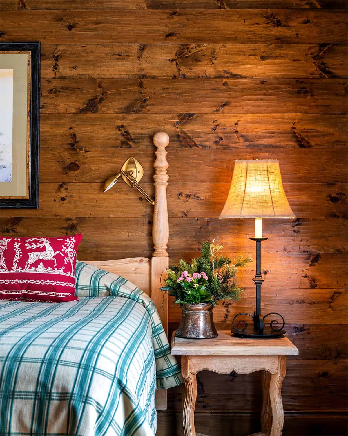 Hotel bed, nightstand with lamp, and wood-paneled wall