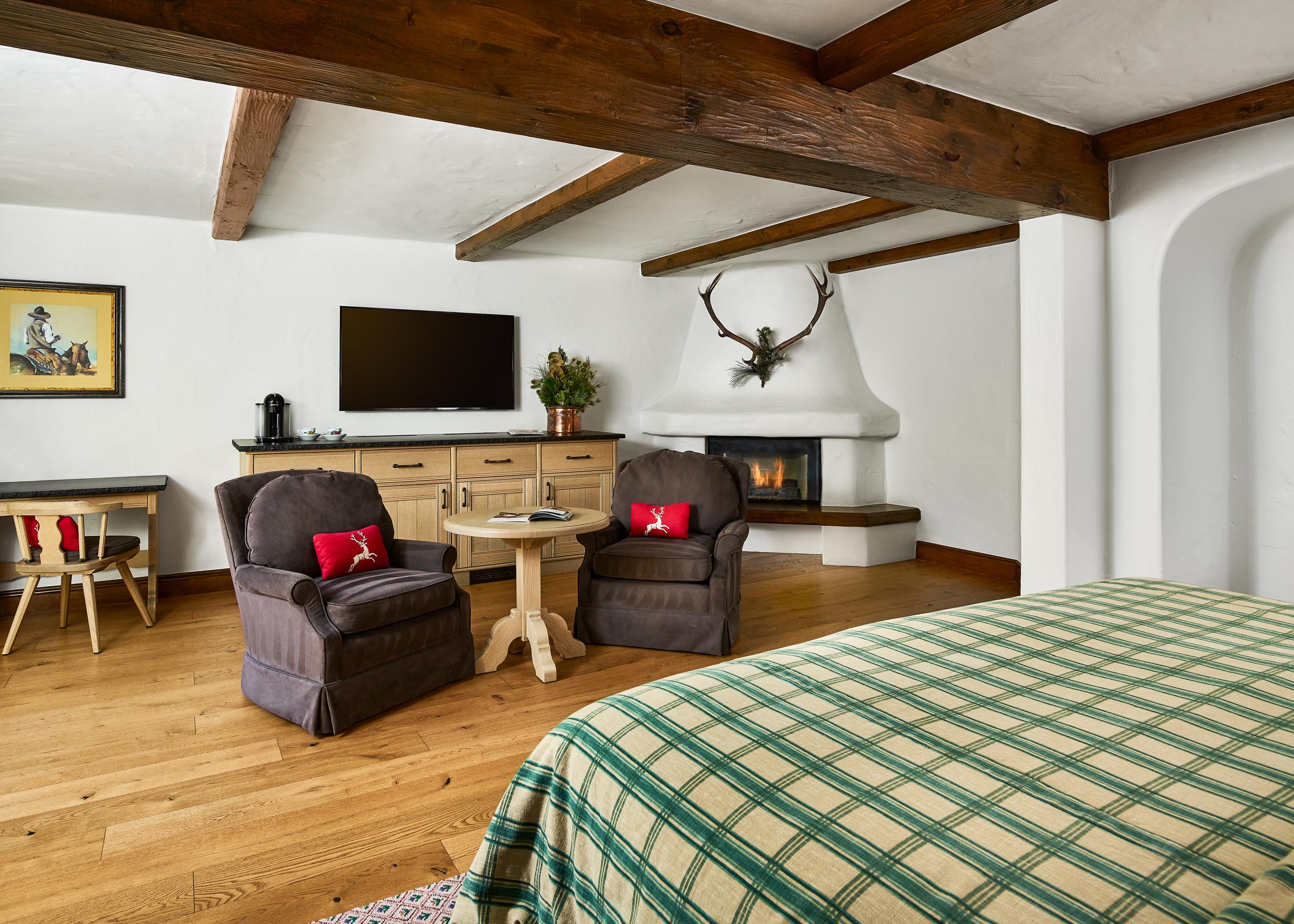 Suite with living room, fireplace, sofa, chairs, and armoire