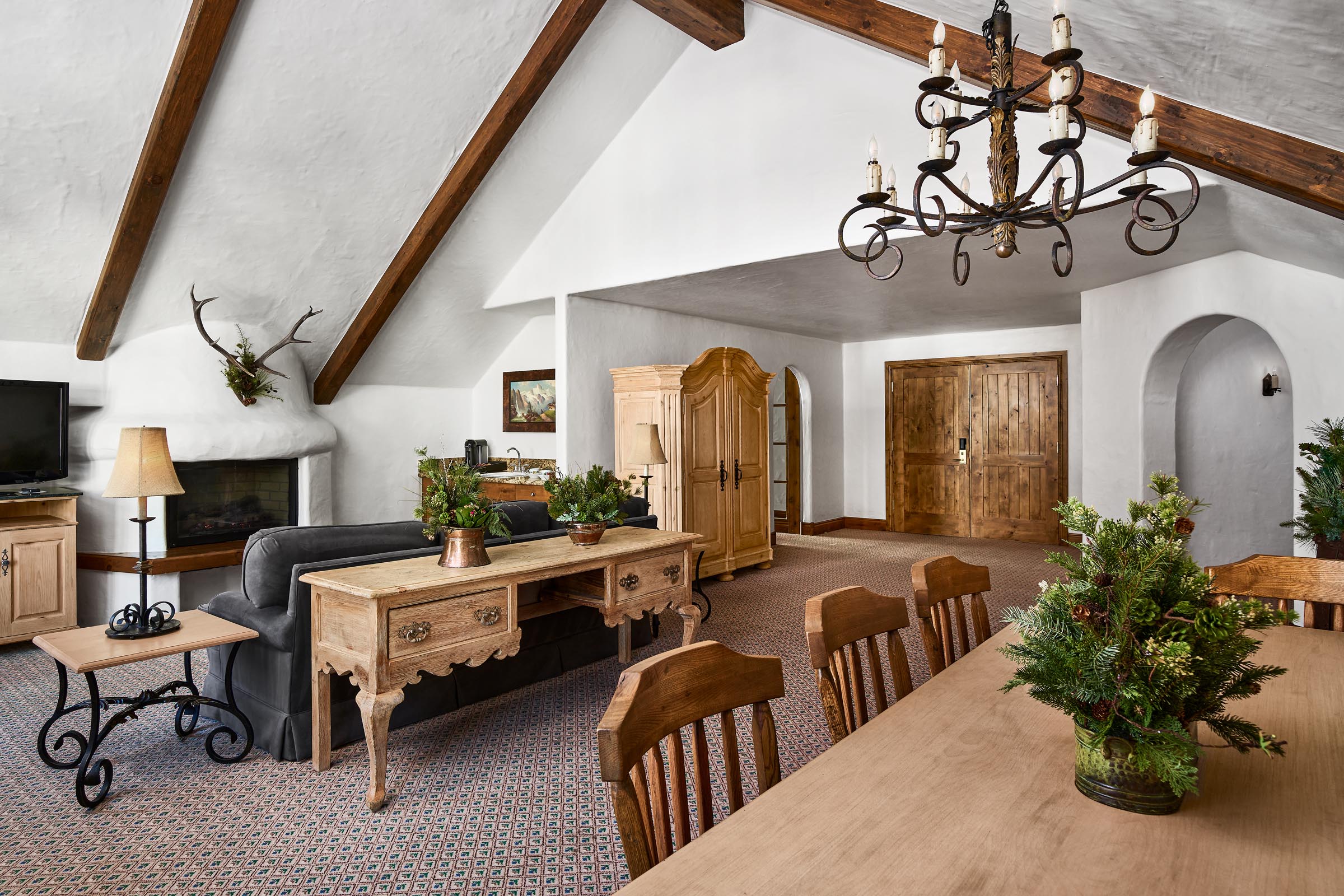 Castle Peak Suite with fireplace, sofa, chairs, and dining table with chairs in foreground
