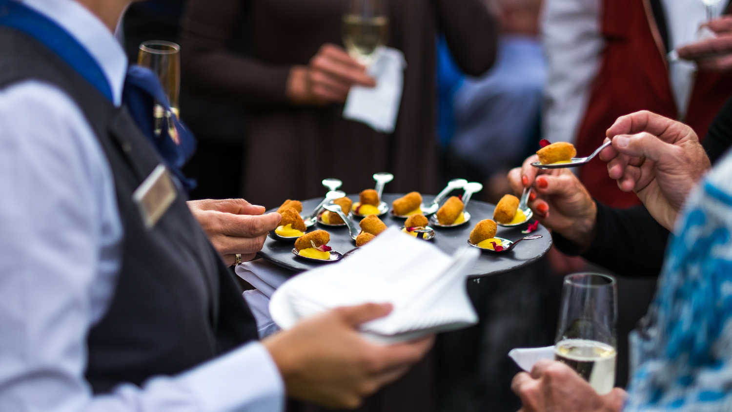 A server present a passed appetizer to a group of guests at Sonnenalp Hotel's Gather In the Garden summer culinary event in Vail, Colorado.