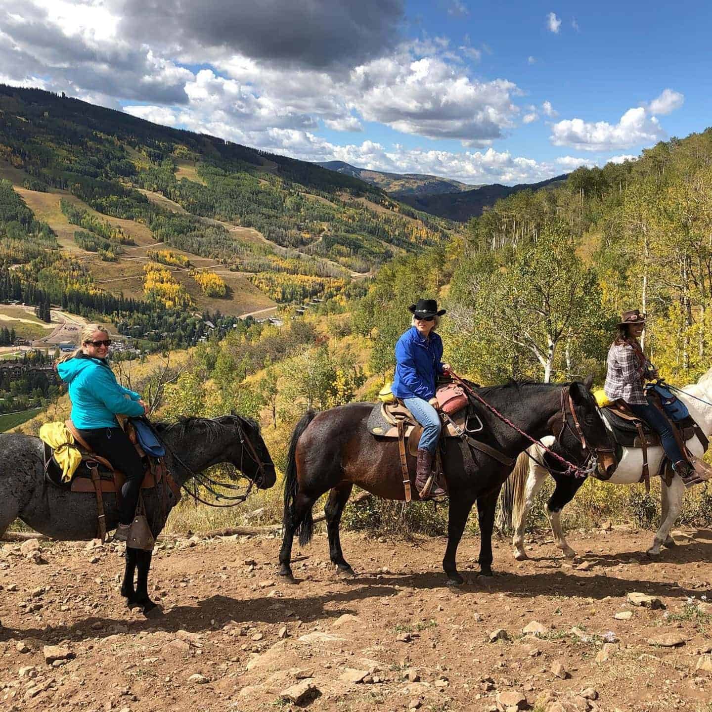 A group of people riding horses around the valley
