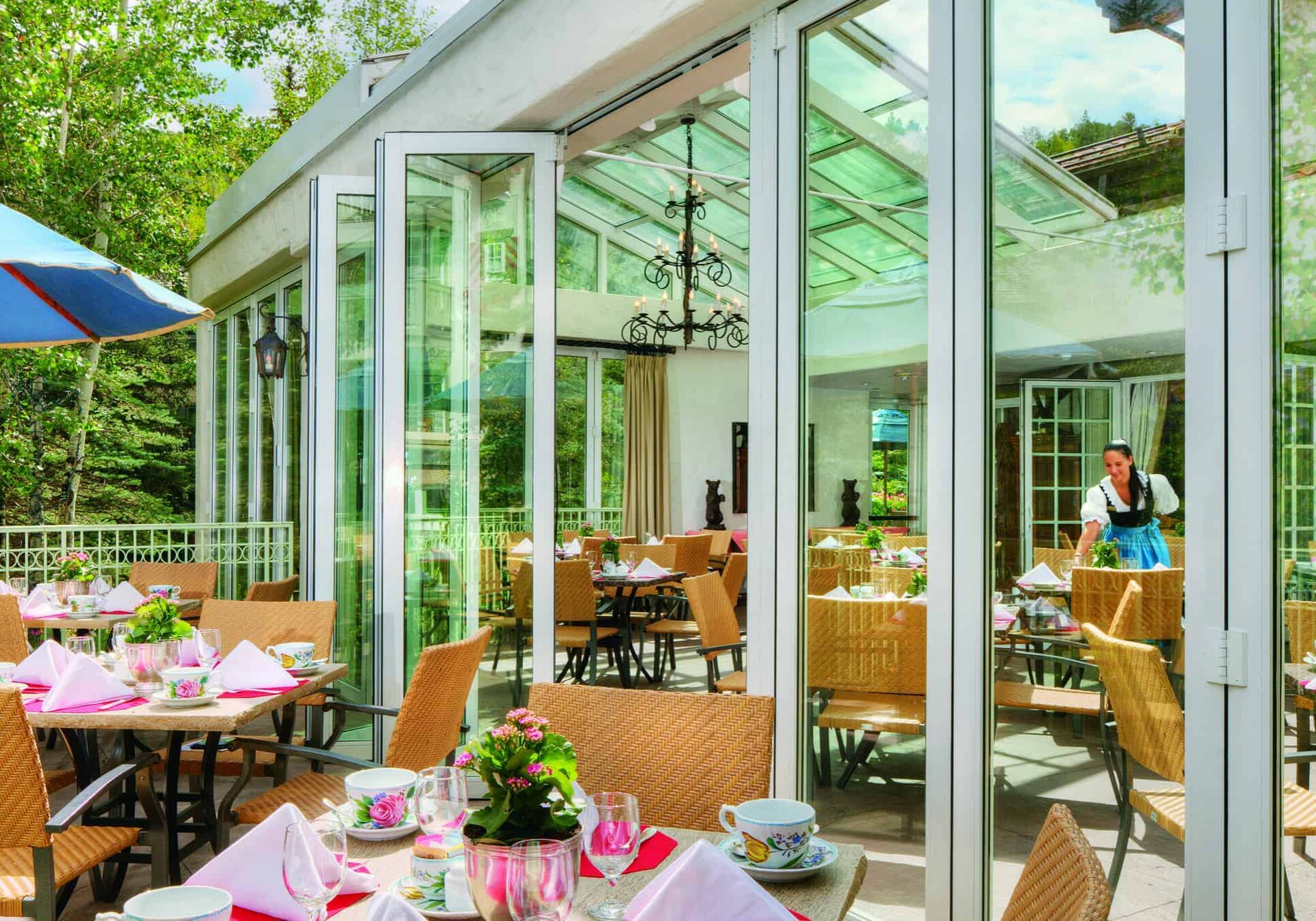 Terrace with patio furniture, and women with Bavarian costume in the background