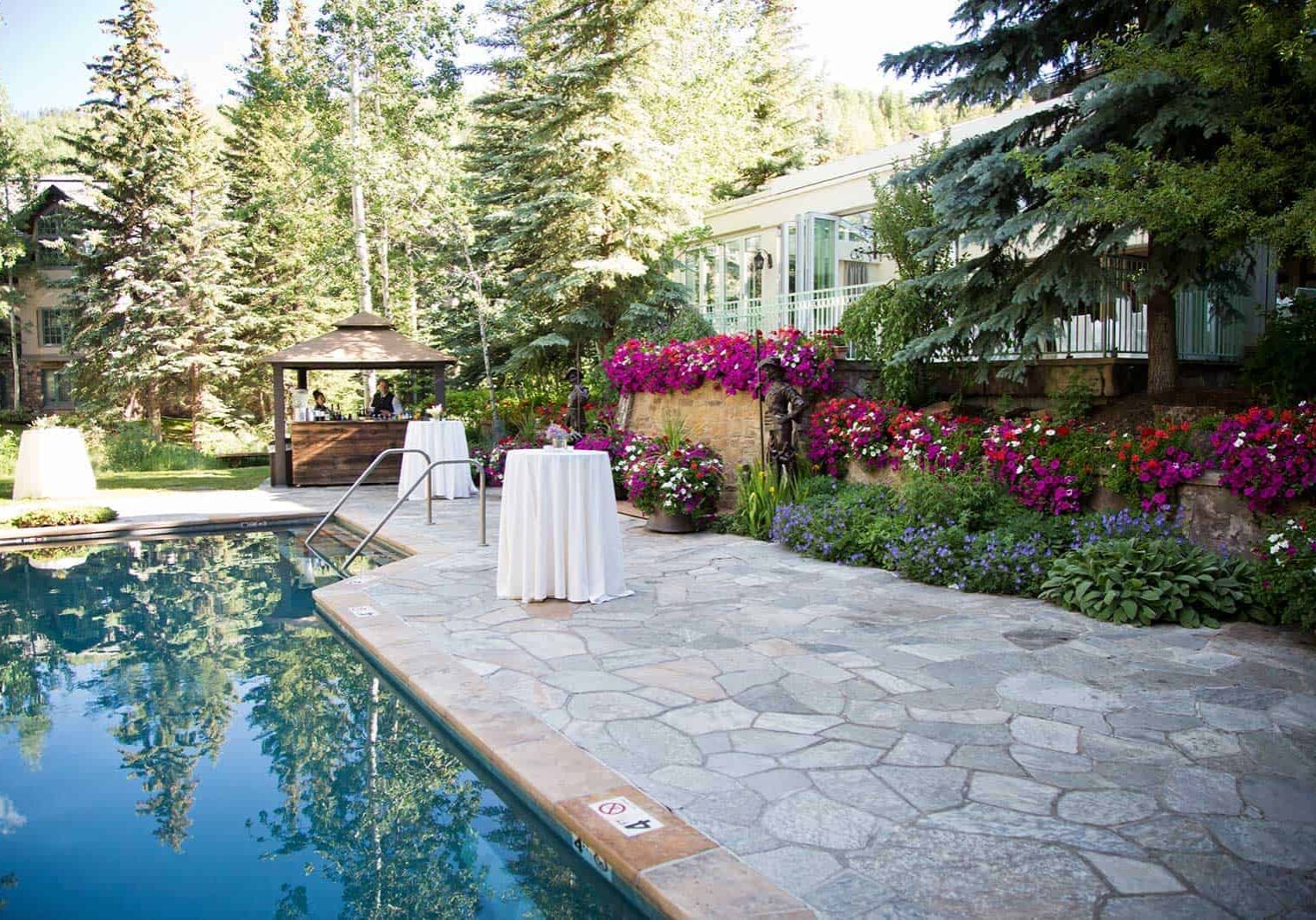 Cocktail tables poolside and flower gardens