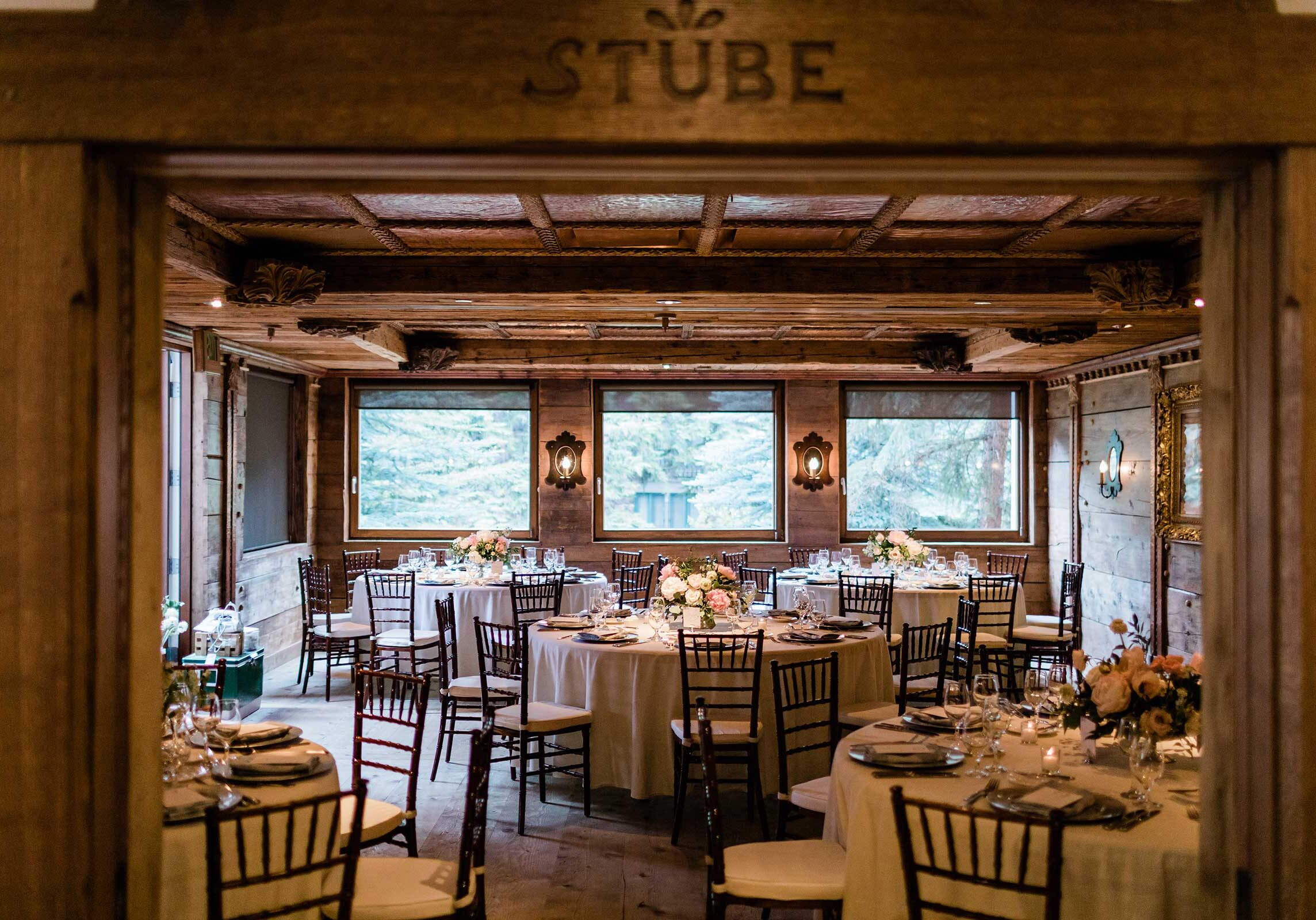 Room with wooden walls, and tables with centerpieces and placesettings