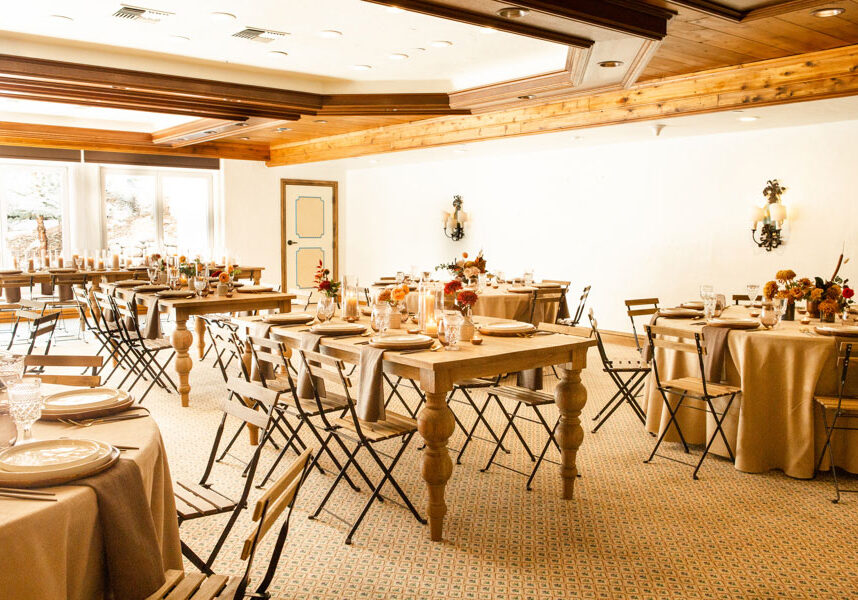 Carpeted room with tables with centerpieces and placesettings