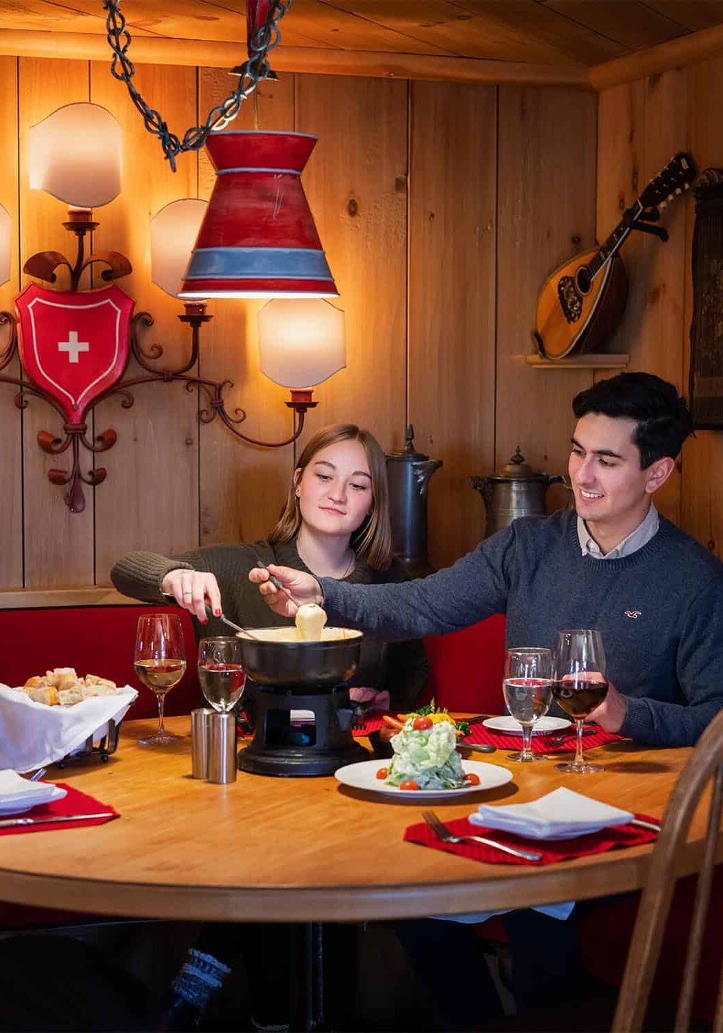Couple seated at table, eating fondue